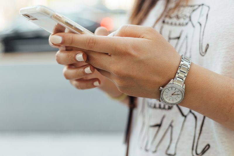 Happy language school student using a mobile app on a smartphone